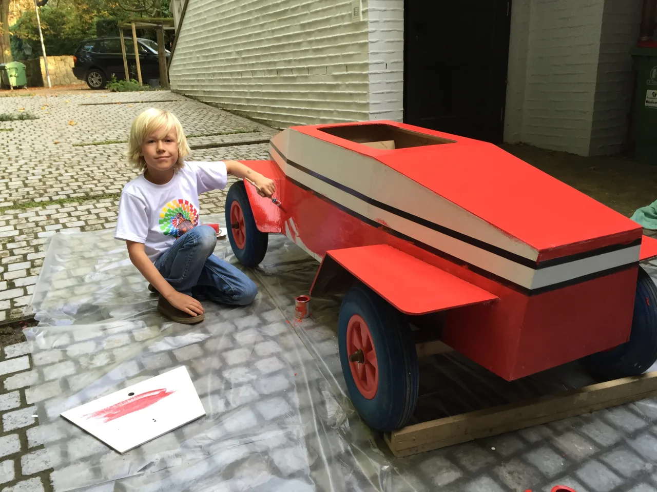 Leander as a boy, painting a soapbox car he built, Germany