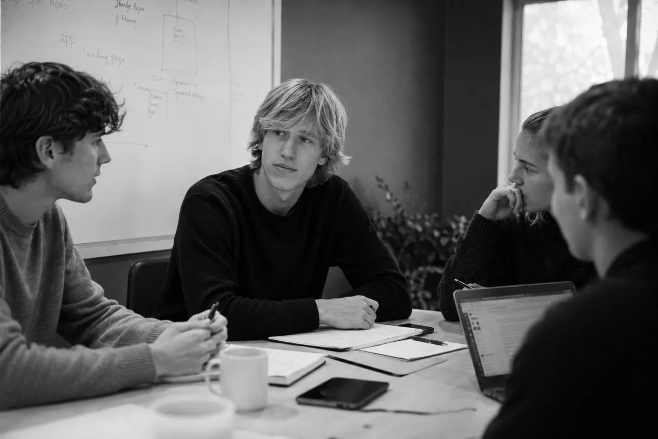 Leander and the founding crew planning The Spins around a whiteboard